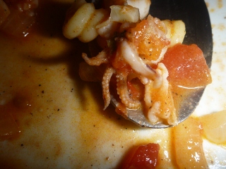 Ein L�ffel mit Tomaten-Zwiebel-Tintenfisch-So�e